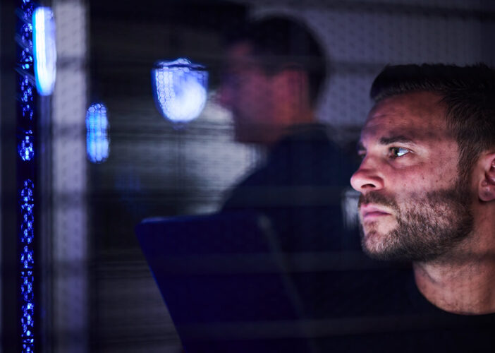 IT professional working in server room as part of cybersecurity risk management operations